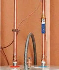 Heavy Duty Bronze Water Pipe Ground Clamp Fits One Quarter To Two Inches attached to copper tubing for secure electrical bonding.