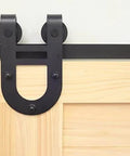 Close-up view of Black Rustic Non Bypass Sliding Barn Door Hardware Kit for One Door with 8 Foot Flat Track and House Shoe Rollers.