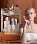 Woman seated by 360 Degree Rotating Makeup Organizer and Storage for Vanity and Countertop High Capacity Cosmetic Skincare and Perfume Organizer with Two Tiers in Clear White Lazy Susan for Dresser.
