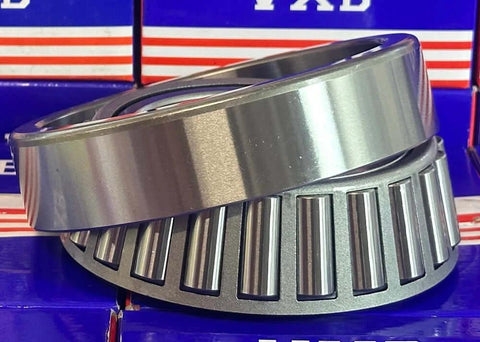Close-up of 33117 Tapered Roller Wheel Bearing 85x140x41 showing chrome steel construction on a blue background.