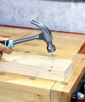 Hammering a nail into wood with Seafoam 40-Piece Household Tool Kit For Quick Home Repairs And Do It Yourself Projects