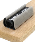 4 In 1 Sanding Block For Flat Convex Concave And Round Surfaces resting on a wooden plank