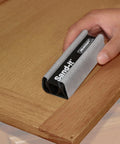 Hand using 4 In 1 Sanding Block For Flat Convex Concave And Round Surfaces on wooden corner