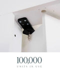 Close-up of Solid As A Rock Hidden Hinge Hardware Bundle mounted on white doors, showcasing matte black finish and sturdy design.
