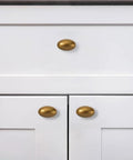 Antique Brass Cabinet Knobs 10 Pack 1-3/8 Inch Oval Drawer Knobs installed on white kitchen cabinets