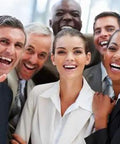 Group of smiling professionals in suits, celebrating teamwork and success in a bright office setting.