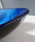Close-up of Cool Black Blue Glass Vessel Sink With Waterfall Faucet And Drain Oval Boat Shape Above Counter Modern Tempered Glass