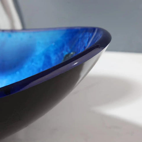 Close-up of Cool Black Blue Glass Vessel Sink With Waterfall Faucet And Drain Oval Boat Shape Above Counter Modern Tempered Glass