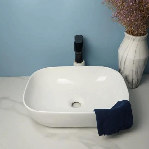 USZWBY Vessel Sinks Square Rounded Corner Simple Sink Ceramic Above Counter Wash Basin with navy towel and faucet.