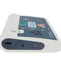 Side view of AED training module, white body with dark top panel, shows DC port and audio out