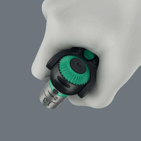 Hand gripping Zyklop Speed Black Edition 8000 A ratchet set with green finish, showing high-torque quick-change design.