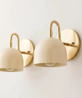 Modern Brass Bowl Wall Sconce - Mid Century Modern Light Fixture Pair (Set of 2) with beige shades attached to a wall.