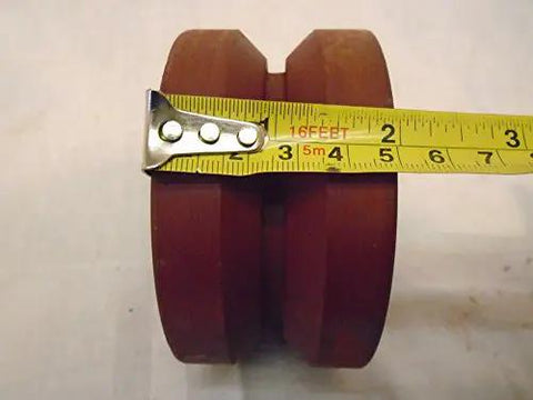 Bulletproof Four Inch Two Inch V Groove Caster Wheel With Seven Eighths Stem Crafted From Rugged Ductile Steel And Rollin Smooth On Heavy Duty Bearings For A Rock Solid One Five Zero Zero Pound Load Rating In Classic Burgundy showing measurement with tape.