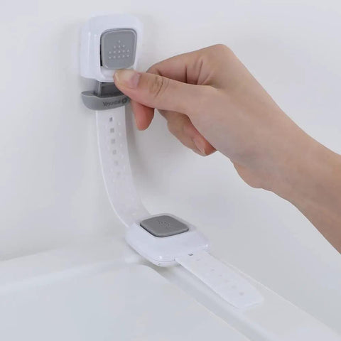 Hand using Upgraded No Drill Furniture Wall Anchors For Baby Proofing And Child Safety, 4 Pack Cabinet Strap Locks on white surface.