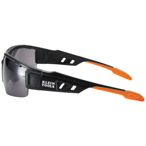Black and orange safety glasses with tinted lenses, side view