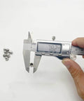 Digital caliper measuring 30 Pack M5 Action Camera Thumb Screws Caps, Stainless Steel End Tips showing 7.82mm, caps visible in background