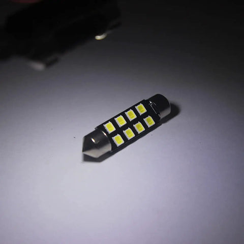 Close-up of a 31mm festoon bulb from 32 Piece LED Car Interior Light Kit With T10 Wedge And Festoon Bulbs For Dome Map Door Trunk Courtesy Lights Bright White Replacement Kit Includes 29mm 31mm And 41mm Sizes.