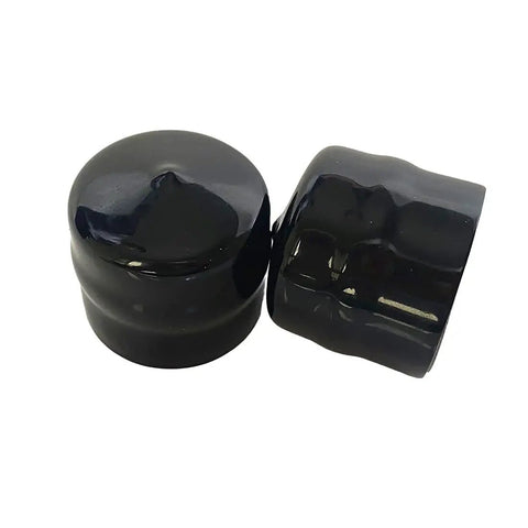 Black plastic caps from the Front Wheel Bearing Conversion Kit for Riding Lawn Mowers, Easy Upgrade for Smooth Rolling.