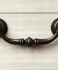 Vintage Look Bail Drawer Pulls Drop Handles 4.25 Inch Center-To-Center Dark Antique Bronze Cabinet Hardware mounted on wood.