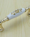 A Premium 96mm Center To Center Cabinet Drawer Pull And Ceramic Porcelain Knob With Slick White Gold Accents on wood surface.