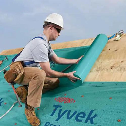 Worker applying Zero Hassle Heavy Duty Synthetic Roof Underlayment Covers A Whole 10 Squares Of Your Deck Pro Level waterproof protector.