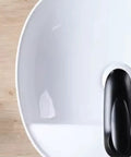 Top view of USZWBY Vessel Sinks Minimalist Ceramic Table Basin with black drain plug, ideal for bathroom or balcony use.