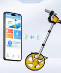 Solid Setup Smart Measuring Wheel With Bluetooth App Mapping And Backlit Lcd Screen For No Stress High Precision Survey Work And Snazzy Cad File Export Options, shown with smartphone displaying app.