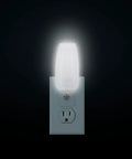 MLN 16 LED Plug In Night Light With Auto Dusk To Dawn Sensor And 5000K Daylight Illumination 5 Lumens glowing in outlet.