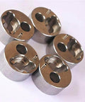 Top view of five metal poppet housings, 7/8 inch water jet pump components