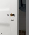 Six Pack Antique Brass Cabinet Knobs With Fluted Trumpet Ends installed on a kitchen cabinet door, dimensions 1 inch by 5/8 inch.