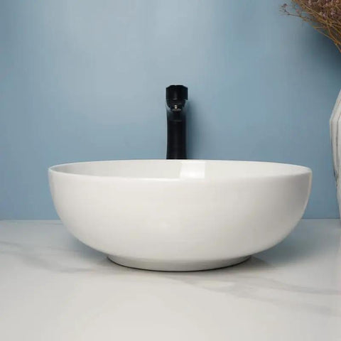 USZWBY Vessel Sinks Modern Simple Round Sink Home Bathroom Above Counter Basin showing white ceramic bowl sink with black faucet.