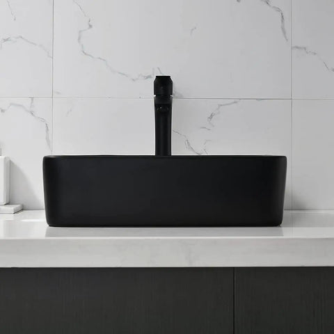 Black rectangular vessel sink with faucet on marble countertop, modern minimalist bathroom design.