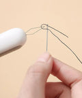 Close-up of 3 Pack 2 In 1 Needle Threader And Seam Ripper Set For Sewing Threading And Seam Removal in use with needle and thread.