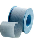 Side view of blue perforated medical tape on a plastic spool; loose tape end in front.