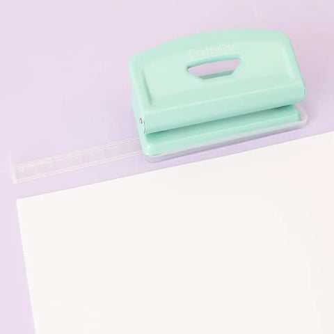 Mint 2 Hole Puncher With Waste Tray, 10 Sheet Capacity, Metal Puncher With Adjustable Guide and Non Slip Base on purple background