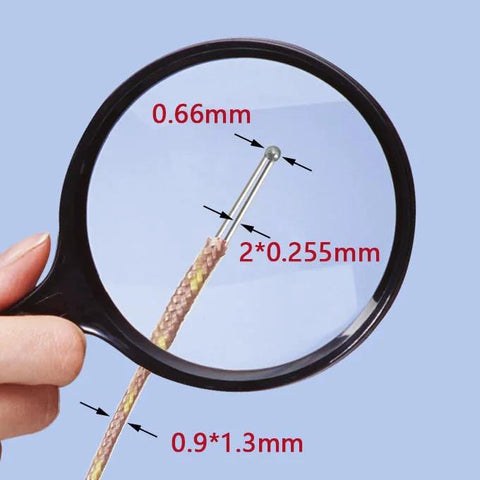 K-type thermocouple temperature probe tip with 0.66 mm diameter and braided copper lead under magnifying glass