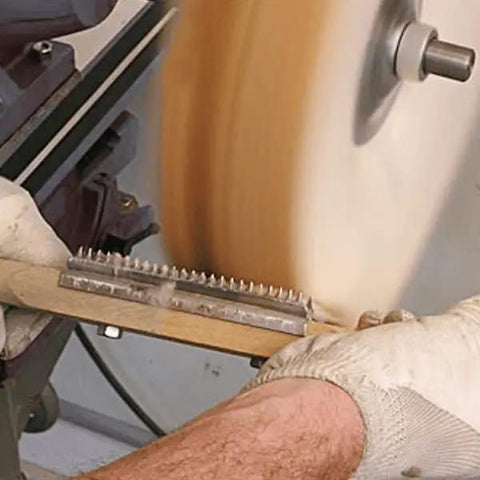 Heavy Duty 15 Inch Wood Shaft Double Handle Buffing Wheel Rake Steel Teeth in use for cleaning buffing wheels.
