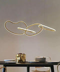 Statement Piece Stainless Steel LED Pendant Chandelier With Gold Ring Accents Adjustable Hanging Lamp For Dining Rooms shows elegant gold rings above a modern dining table.