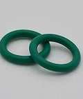 Two green o-rings for sealing in welding applications, part of the Upgrade Your Welding Game With This TIG Torch Parts Set For SR WP-17 18 26 And WP-9 20 Models Featuring A Heat Resistant Glass Cup Kit And Super Secure O Rings For Smooth Performance.
