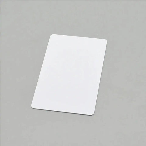 Plug And Play Blank PVC Cards For ID And Business Badges Waterproof Stock No Chip Universal Fit smooth white PVC card on gray background.