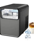 Self Cleaning Countertop Nugget Ice Maker Churns Out Twenty Six Pounds Of Bullet Ice Daily With Lightning Fast Six Minute Cycles And Tool Free Setup For Easy Party Hosting next to a glass of iced drink and ice cubes.