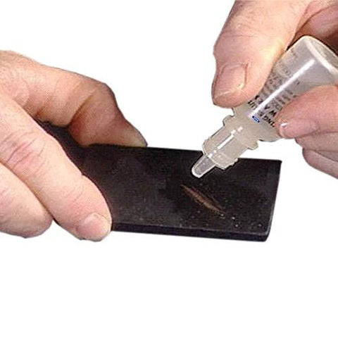 Waytest silver and sterling 999 testing solution bottle applied to a small black metal test piece