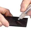 Waytest 18K gold testing solution being applied with dropper to a black testing stone