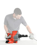 User operating a Heavy Duty Cordless Drain Snake With Brushless Motor and twenty five foot steel cable for drain clearing.