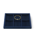 Super Slick Microfiber Jewelry Display Tray With Six Grid Compartments For Ring Earring Bracelet And Necklace Storage Stackable Countertop Organizer Plate Hits Different showing empty dark blue tray with a gold bracelet.
