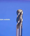 Close-up of an HSS 2-flute end mill with twisted cutting edges against a blue background
