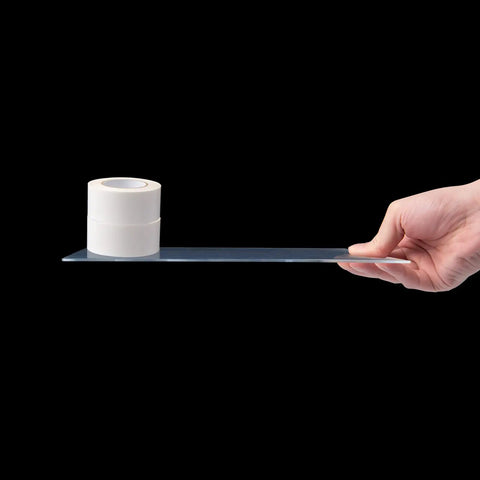 Hand holding Two Pack One Eighth Inch Thick Plexiglass Sheets 36 Inch By 24 Inch Clear PET Plastic for arts with tape roll on top.