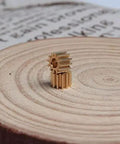 Two Pack Brass Spur Gears, 0.5 Modulus, 12 Teeth, 3mm Bore, 5mm Gear Width, Metal Gear Set For RC And Machinery displayed on wood