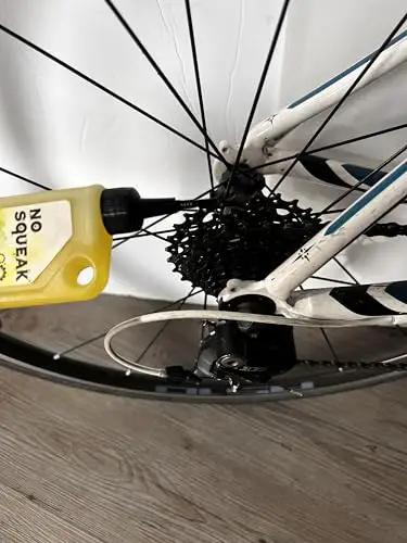 Applying High Performance Penetrating Oil For Bike Chain Lubrication to bicycle gears to stop squeaks and protect metal.