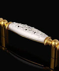 Modern 96Mm Cabinet Pull And Drawer Knob Featuring Crisp White Base With Dazzling 24K Gold Crystal Accent on a black background.